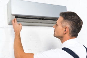 HVAC technician working on AC upgrade in home